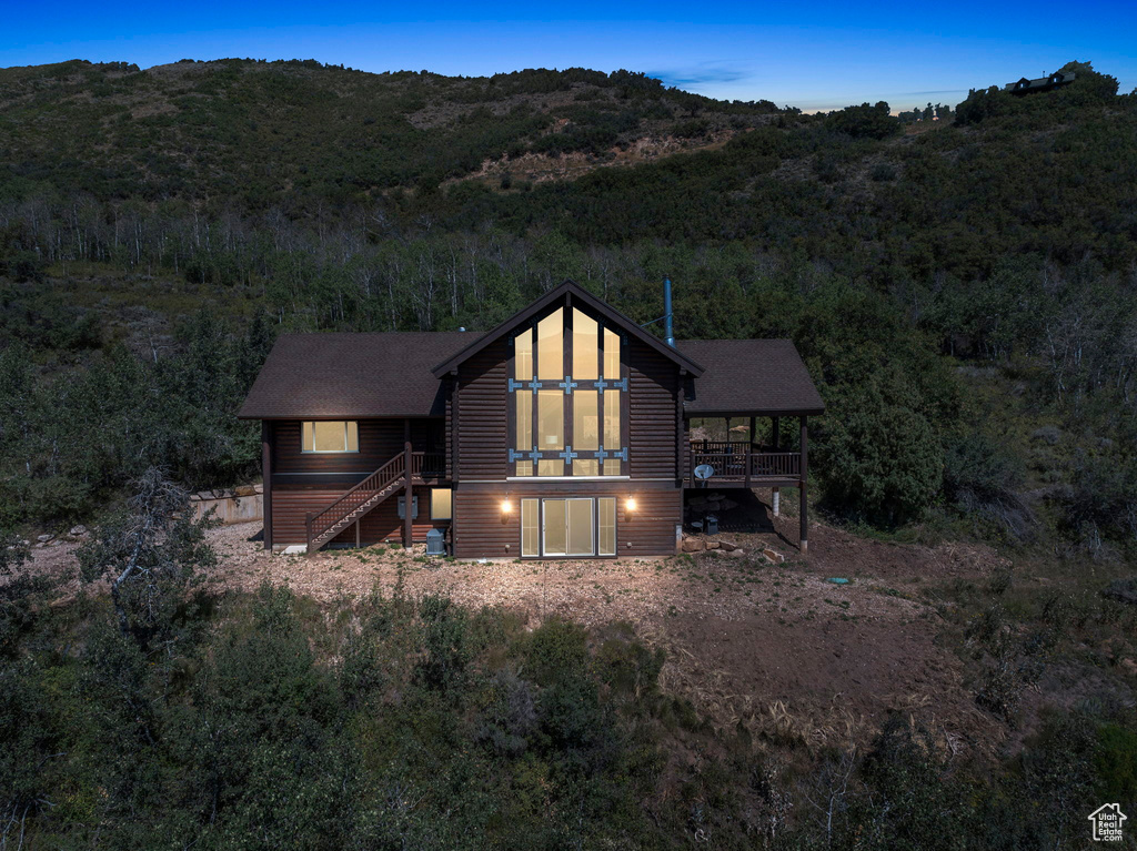 View of front of property with a deck with mountain view