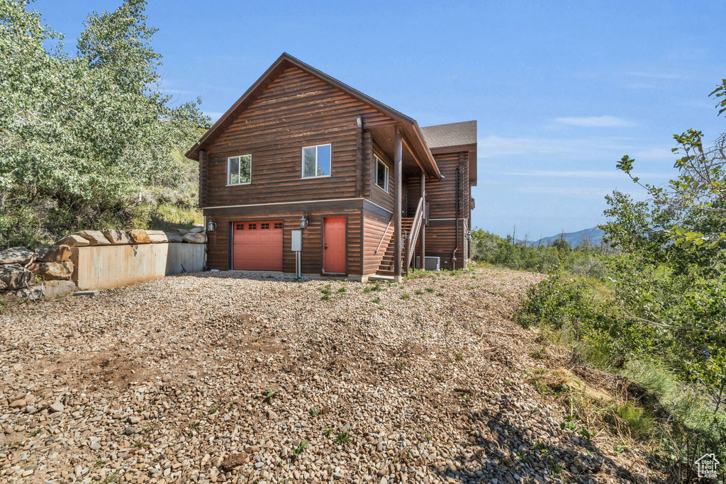 View of side of property with a garage and central AC unit