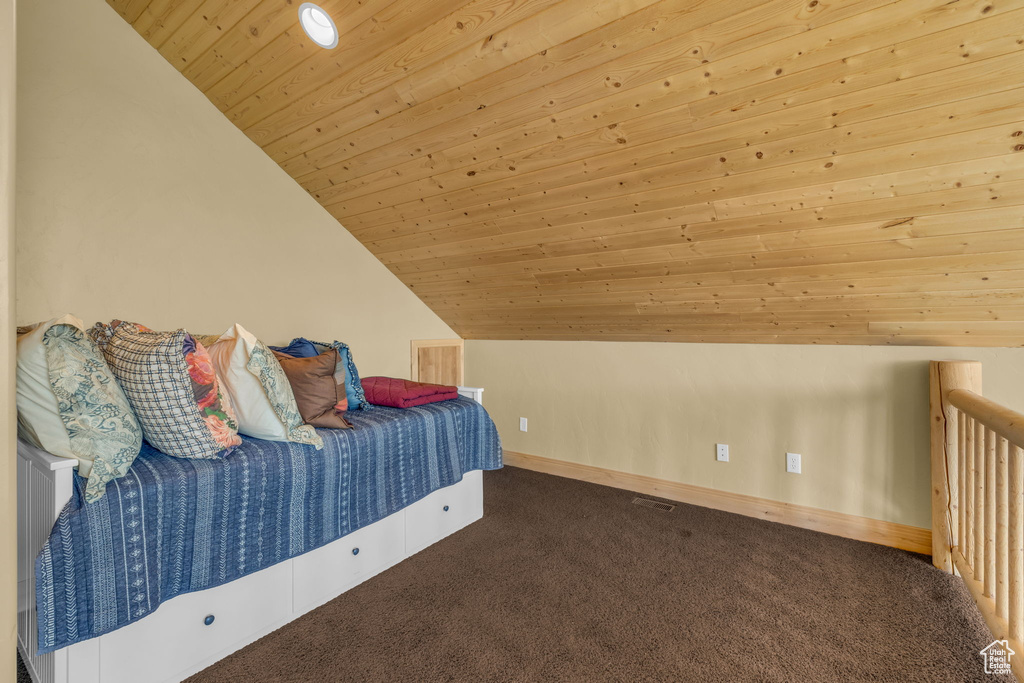 Unfurnished bedroom with vaulted ceiling, carpet, and wooden ceiling