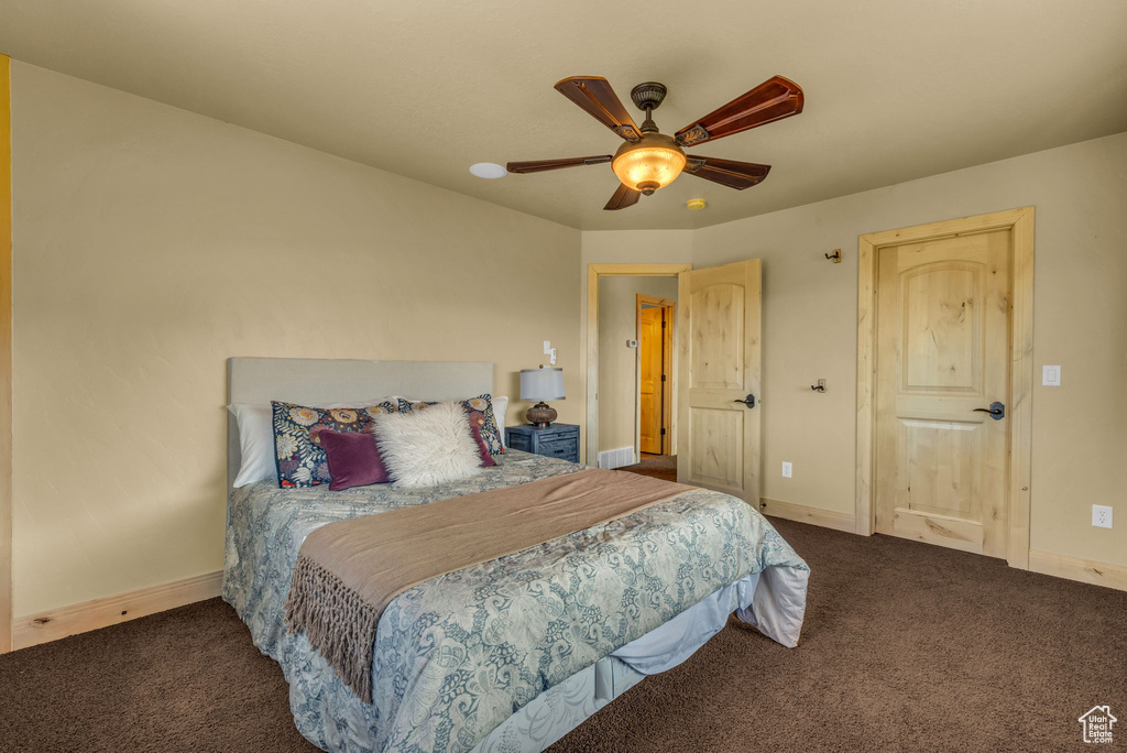 Carpeted bedroom featuring ceiling fan