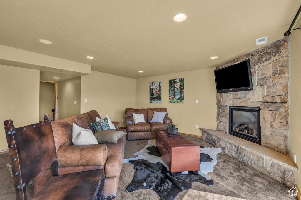 Living room featuring a stone fireplace and carpet floors