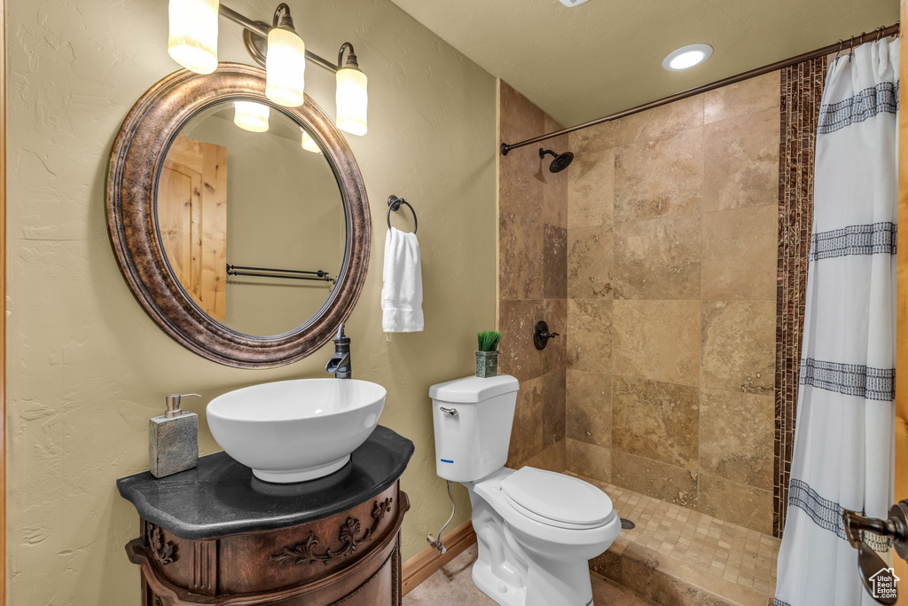 Bathroom featuring vanity, toilet, and a shower with shower curtain