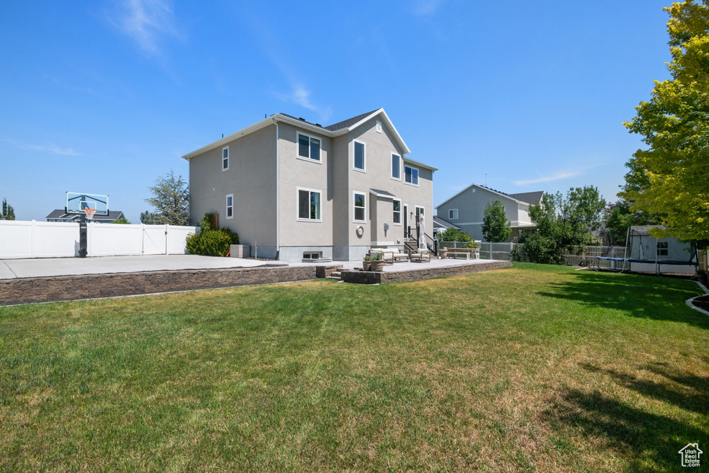 Rear view of house with a yard and a patio