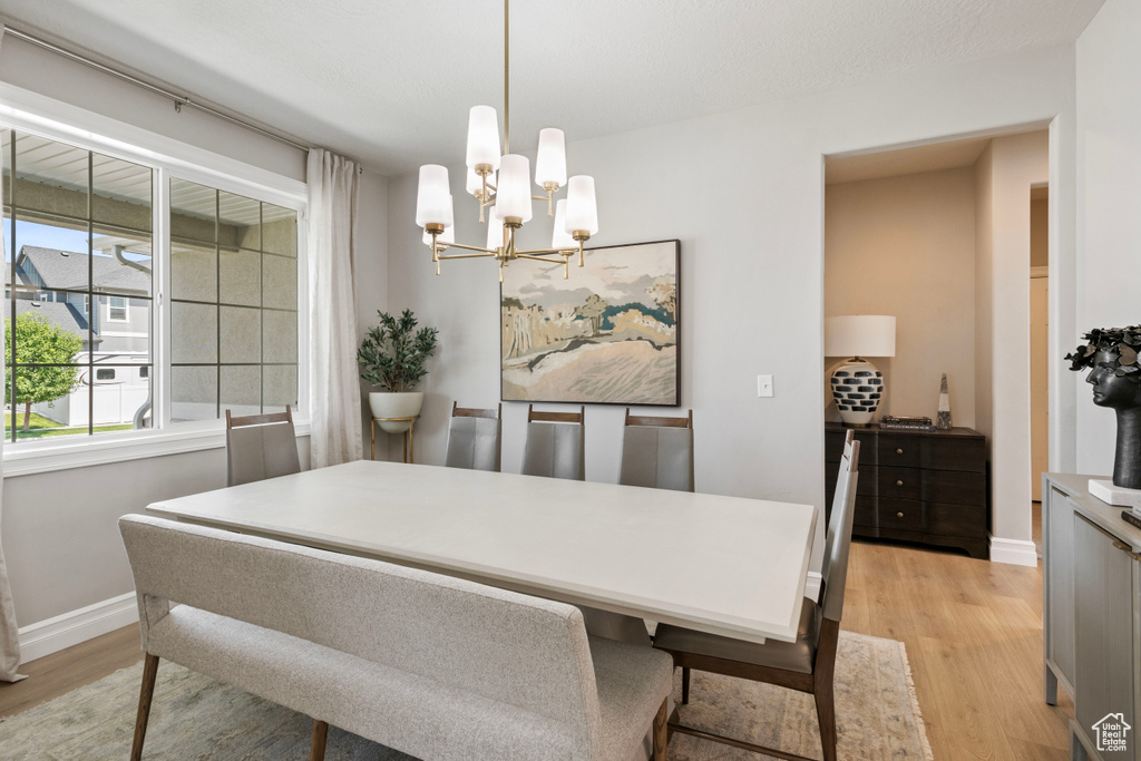 Dining area with a notable chandelier and light hardwood / wood-style flooring