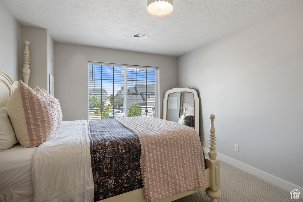 Bedroom featuring a textured ceiling and carpet flooring