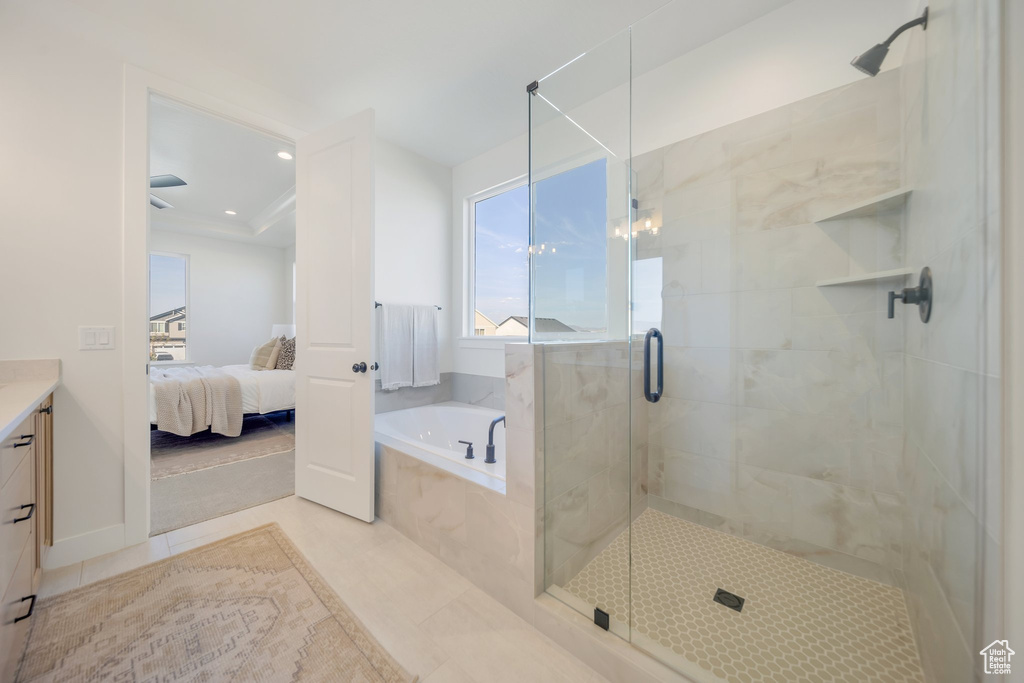 Bathroom featuring vanity, shower with separate bathtub, and tile patterned flooring