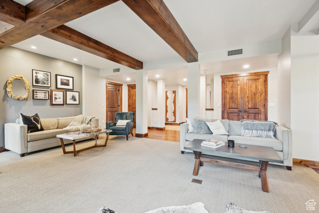 Living room with beamed ceiling and light hardwood / wood-style floors