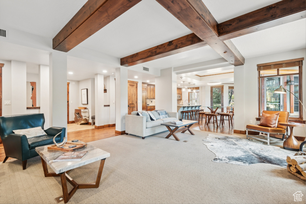 Living room with light hardwood / wood-style flooring and beam ceiling