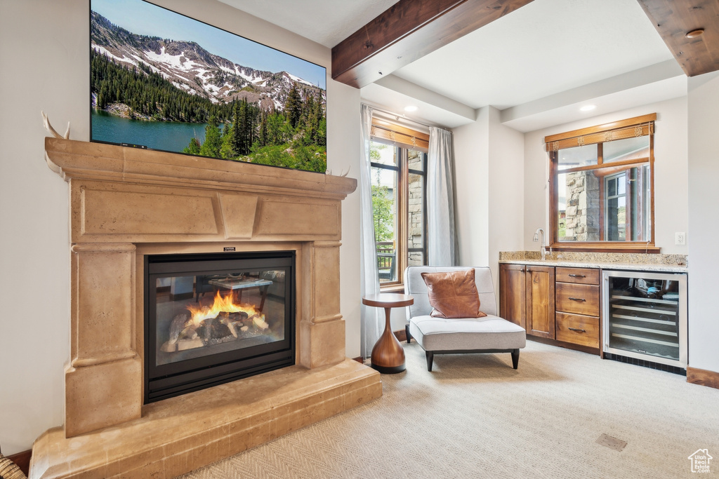 Sitting room featuring wine cooler, light carpet, and indoor wet bar