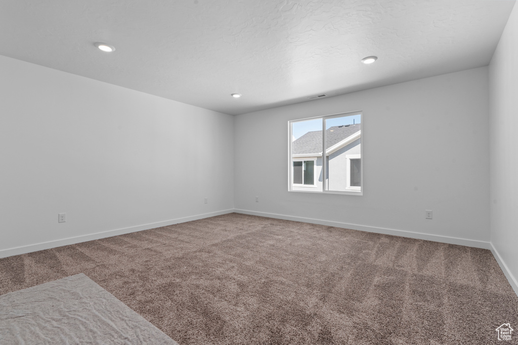 Carpeted empty room featuring a textured ceiling