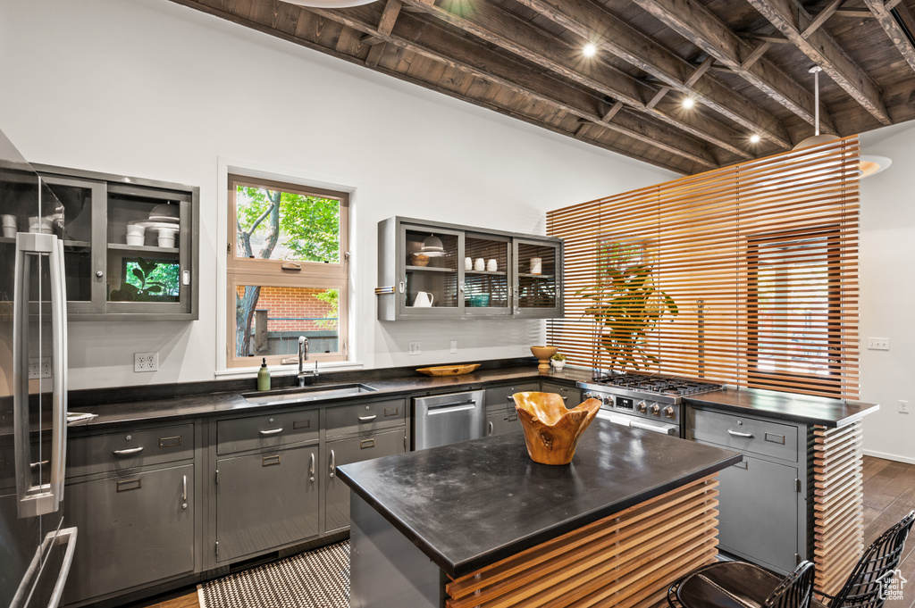 Kitchen featuring hardwood / wood-style flooring, a center island, beamed ceiling, and sink