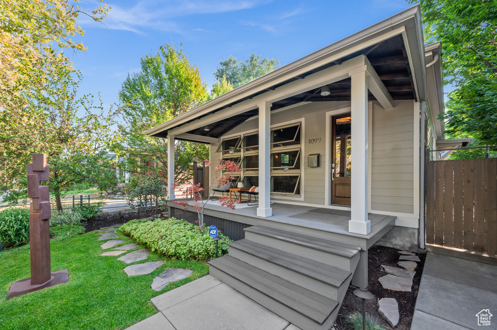 View of outbuilding with a lawn and covered porch