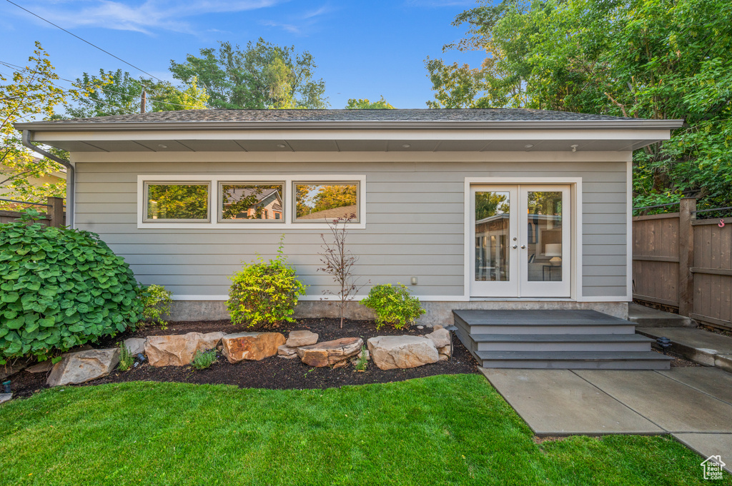 Back of property with a lawn and french doors