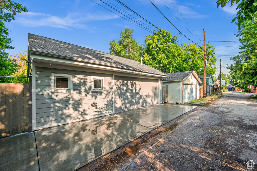 View of side of property with an outdoor structure and a garage