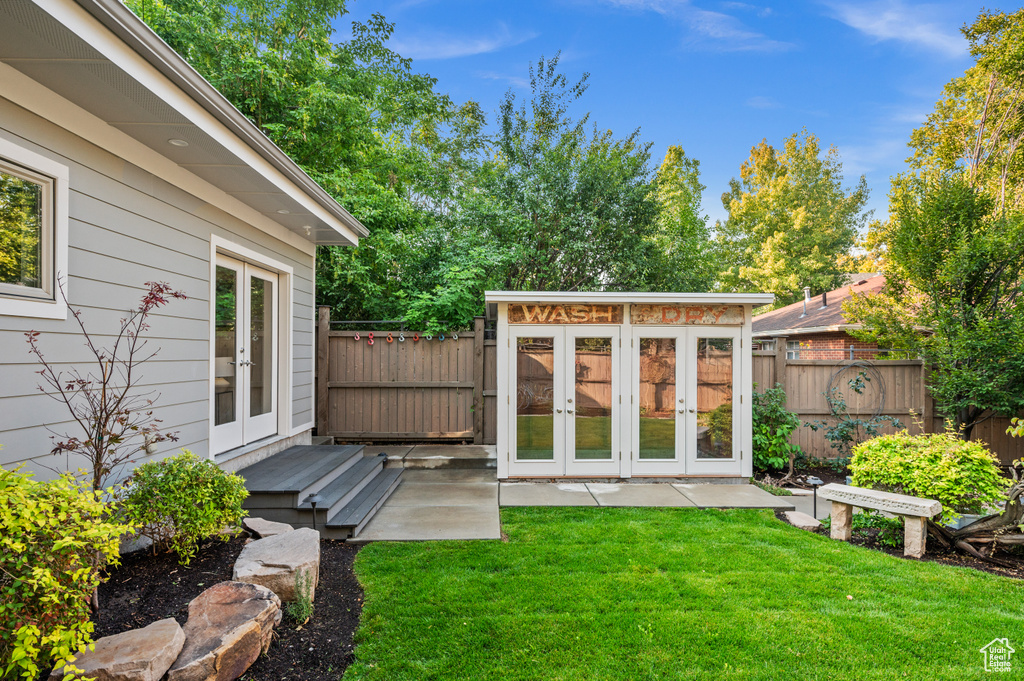 View of yard with an outdoor structure and french doors