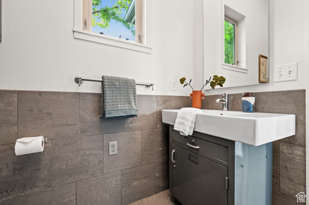 Bathroom featuring vanity and tile walls