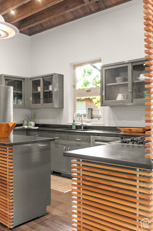 Kitchen with wooden ceiling, beamed ceiling, gray cabinets, dark hardwood / wood-style floors, and stainless steel dishwasher