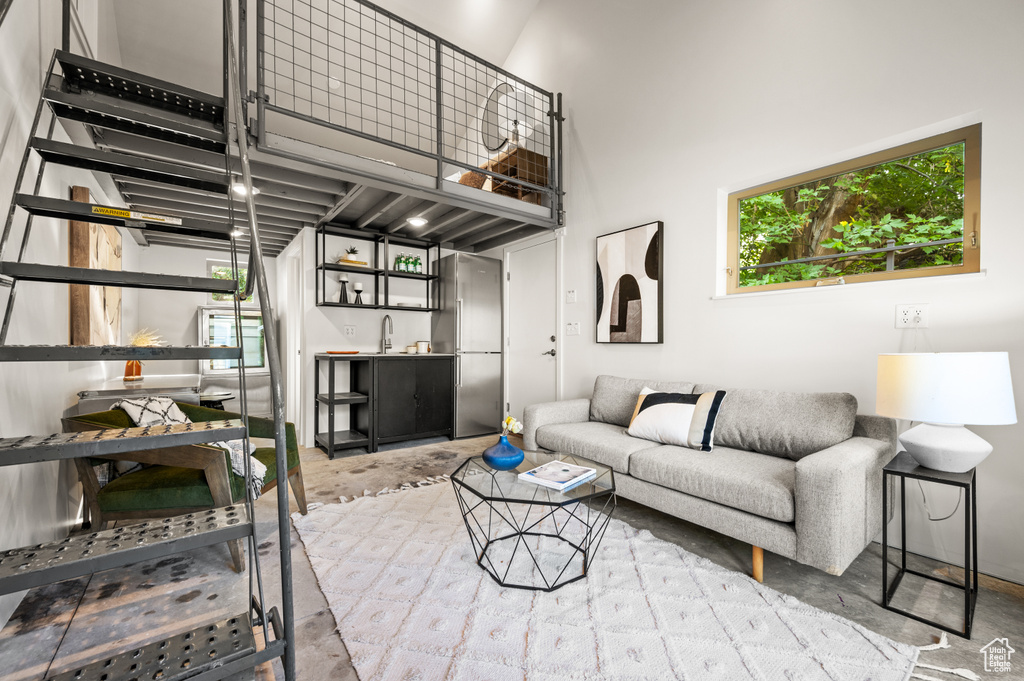 Living room with a towering ceiling, plenty of natural light, and sink