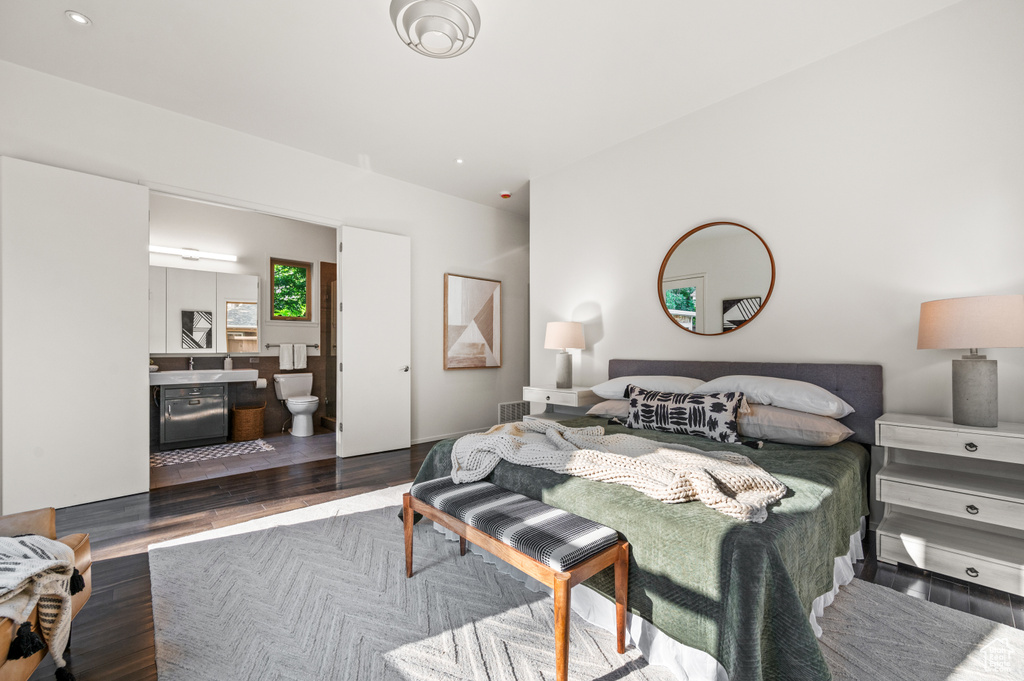 Bedroom featuring ensuite bath and dark hardwood / wood-style flooring