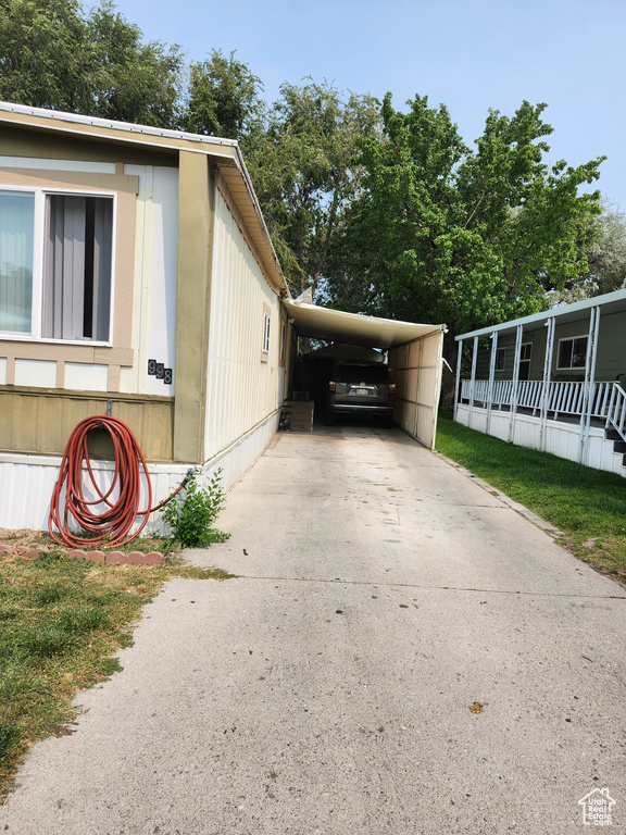 View of side of home with a yard and a carport