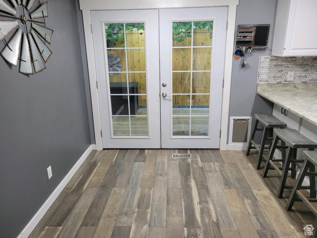 Doorway with french doors and hardwood / wood-style flooring