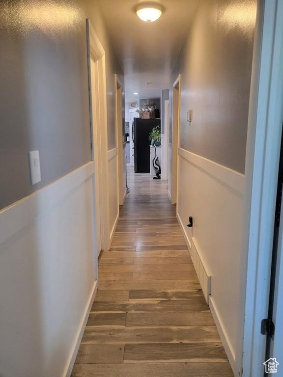 Corridor with hardwood / wood-style floors