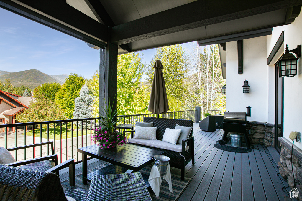 Deck with an outdoor living space and a mountain view