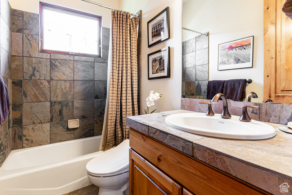 Full bathroom with vanity, toilet, and shower / tub combo with curtain