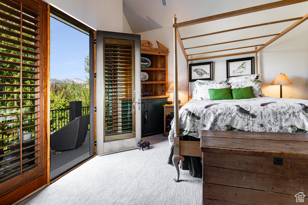 Bedroom with lofted ceiling, carpet, and access to outside