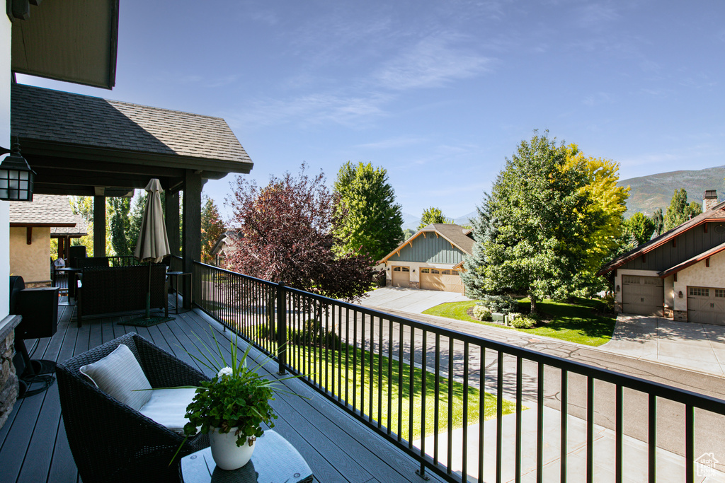 Deck with a mountain view, an outdoor structure, and a garage