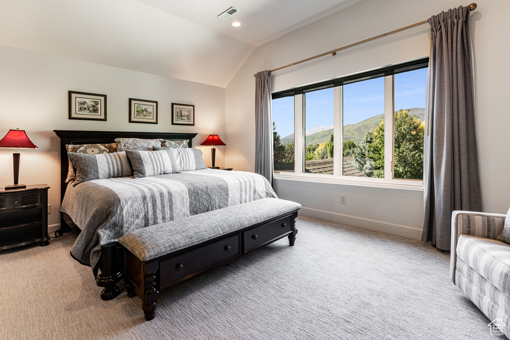 Carpeted bedroom featuring a mountain view and vaulted ceiling