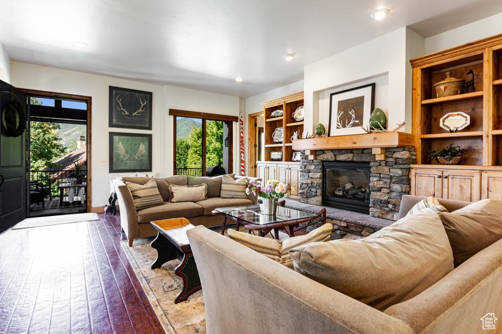 Living room with wood-type flooring and a stone fireplace