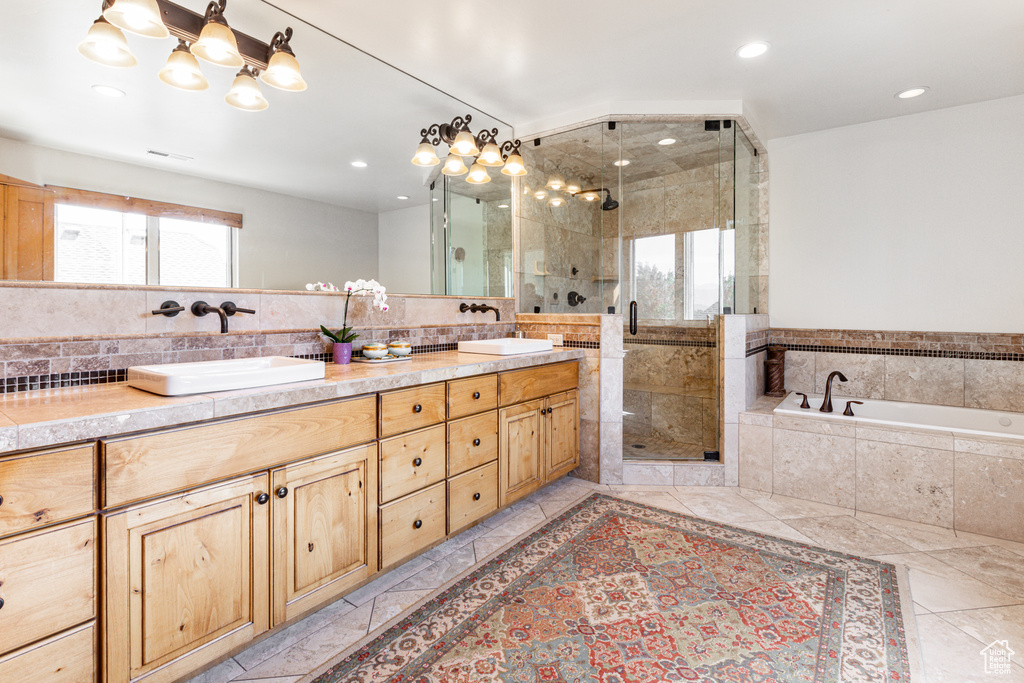 Bathroom featuring tile patterned flooring, separate shower and tub, and vanity