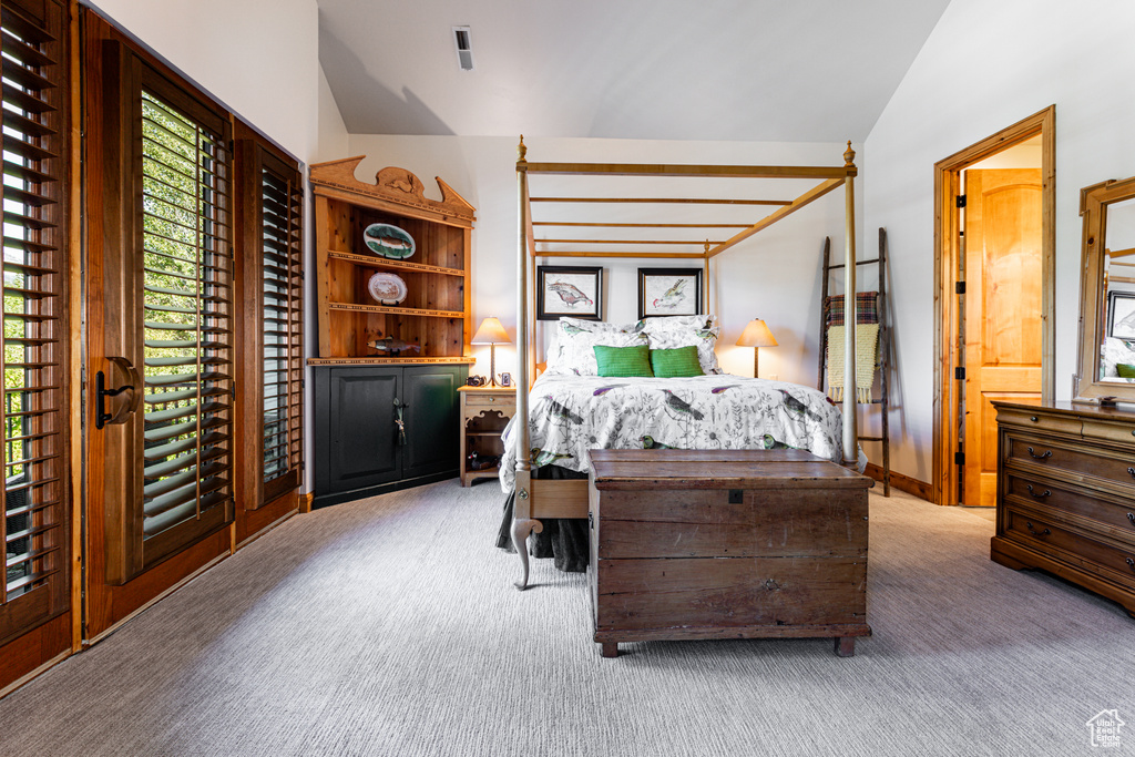 Bedroom with lofted ceiling, carpet flooring, ensuite bath, and multiple windows