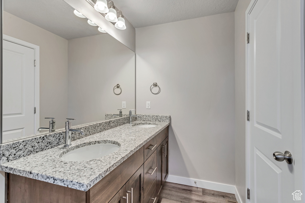 Bathroom with wood-type flooring, a textured ceiling, and vanity