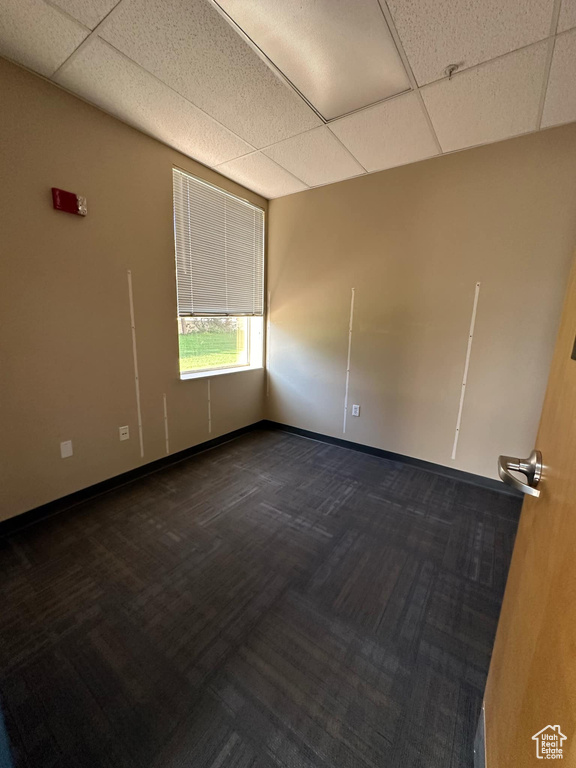 Carpeted empty room featuring a paneled ceiling