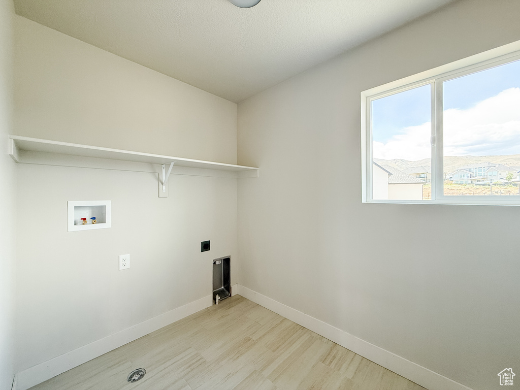 Laundry area featuring washer hookup, light wood-style floors, and hookup for an electric dryer
