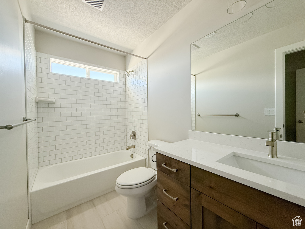 Bathroom with vanity, shower / bathtub combination, and a textured ceiling