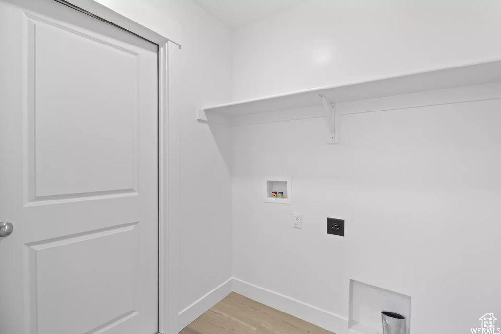 Clothes washing area featuring hookup for a washing machine, light hardwood / wood-style floors, and electric dryer hookup