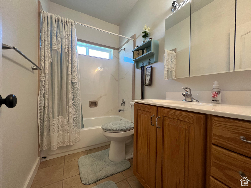 Full bathroom featuring tile patterned flooring, toilet, shower / bath combo with shower curtain, and vanity