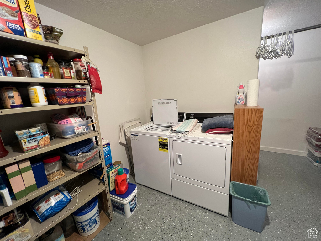 Laundry room with washer and dryer and a textured ceiling