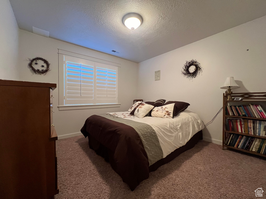 Carpeted bedroom with a textured ceiling