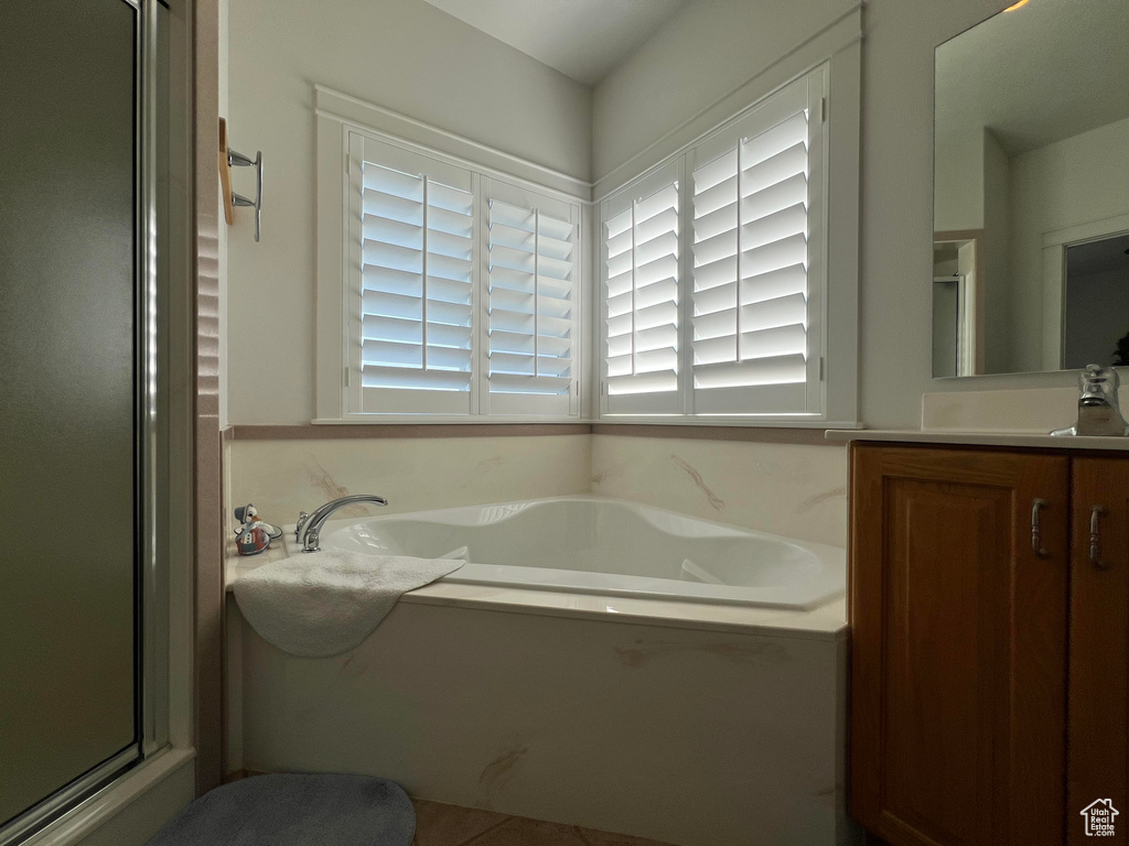 Bathroom featuring vanity and plus walk in shower