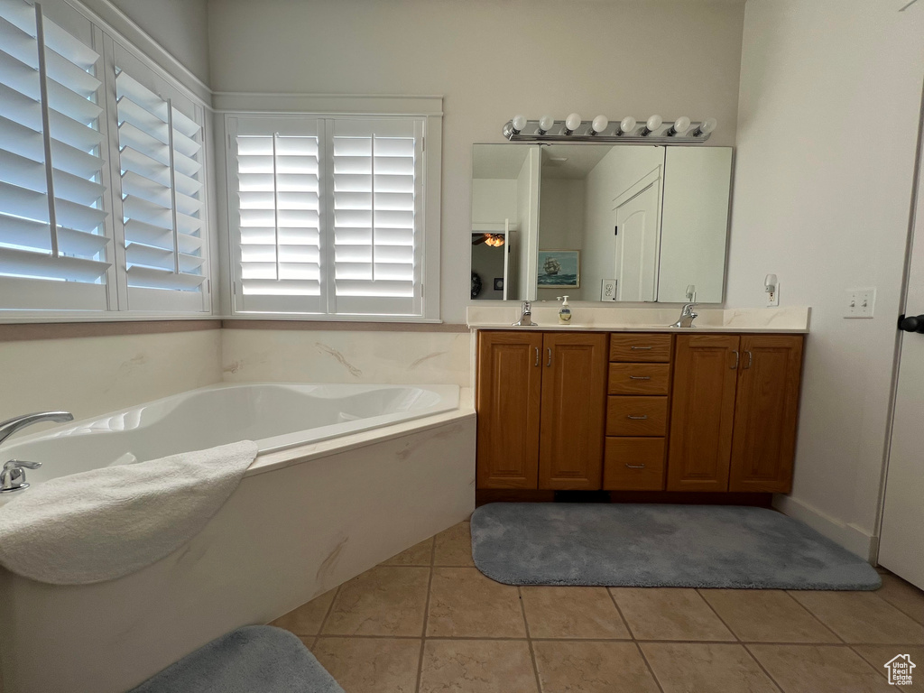 Bathroom featuring vanity, plenty of natural light, a tub, and tile patterned flooring