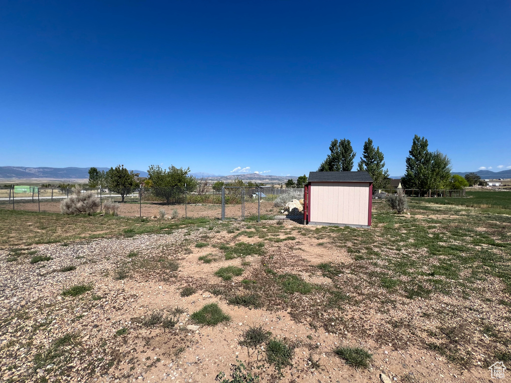 View of yard featuring a storage unit, a rural view, and a mountain view