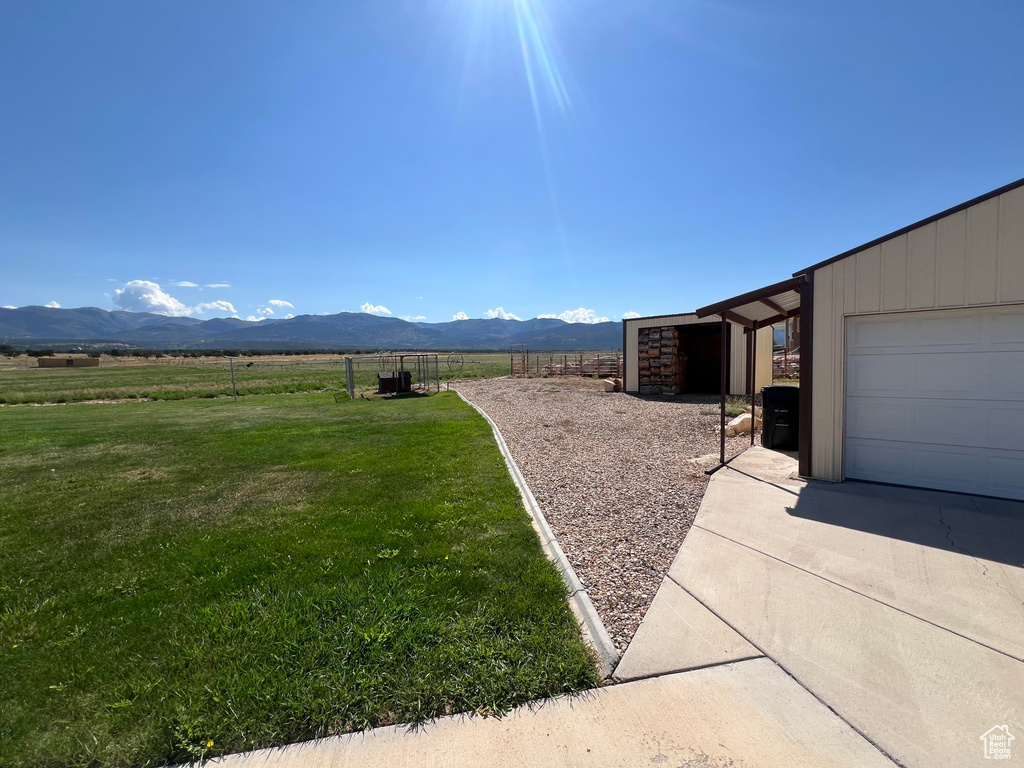 View of yard featuring a garage, a rural view, and a mountain view