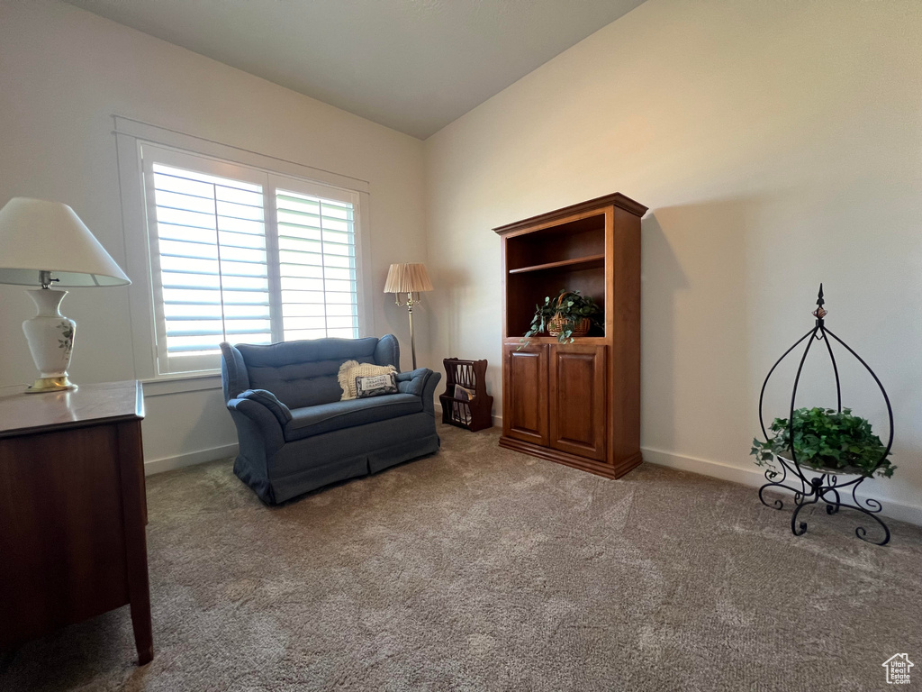 Living area with vaulted ceiling and carpet flooring