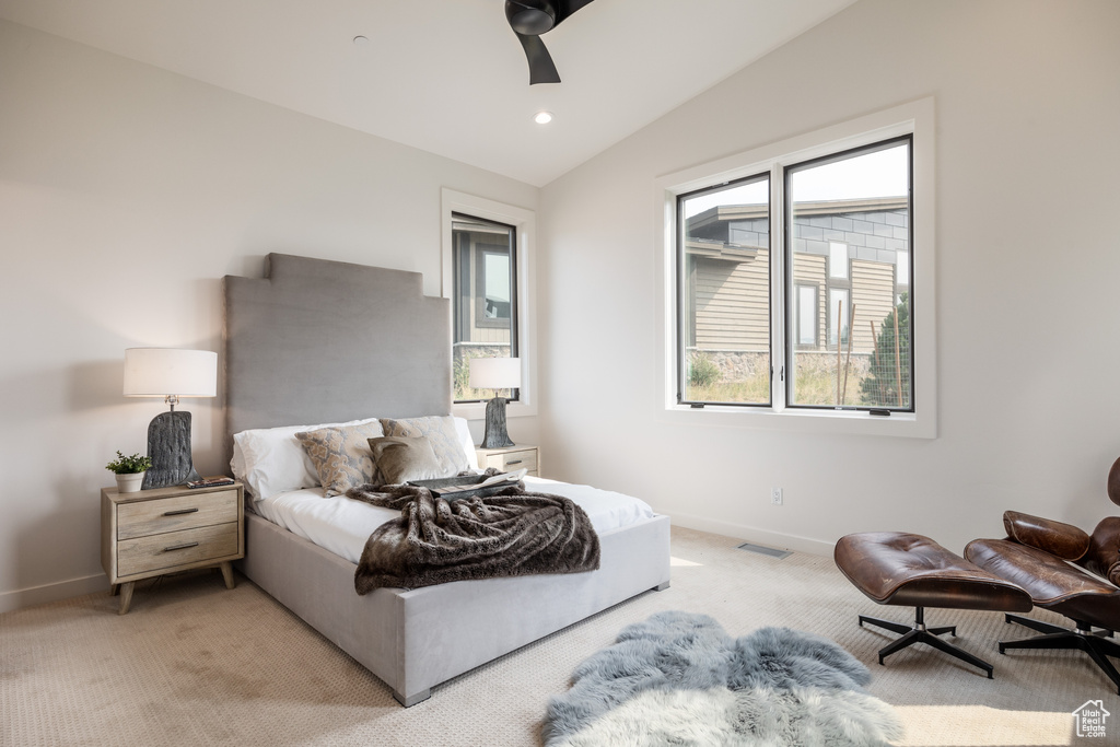 Carpeted bedroom featuring vaulted ceiling and ceiling fan