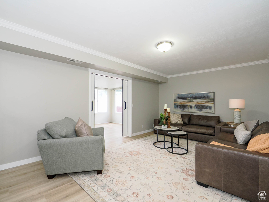 Living room featuring light hardwood / wood-style flooring and ornamental molding