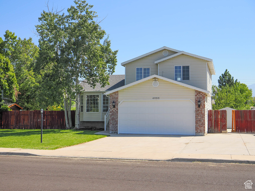 View of front of house featuring a front yard and a garage